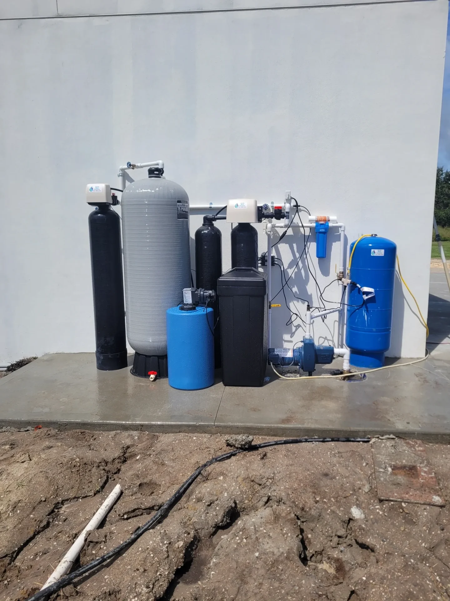 A group of water filters and tanks on the ground.